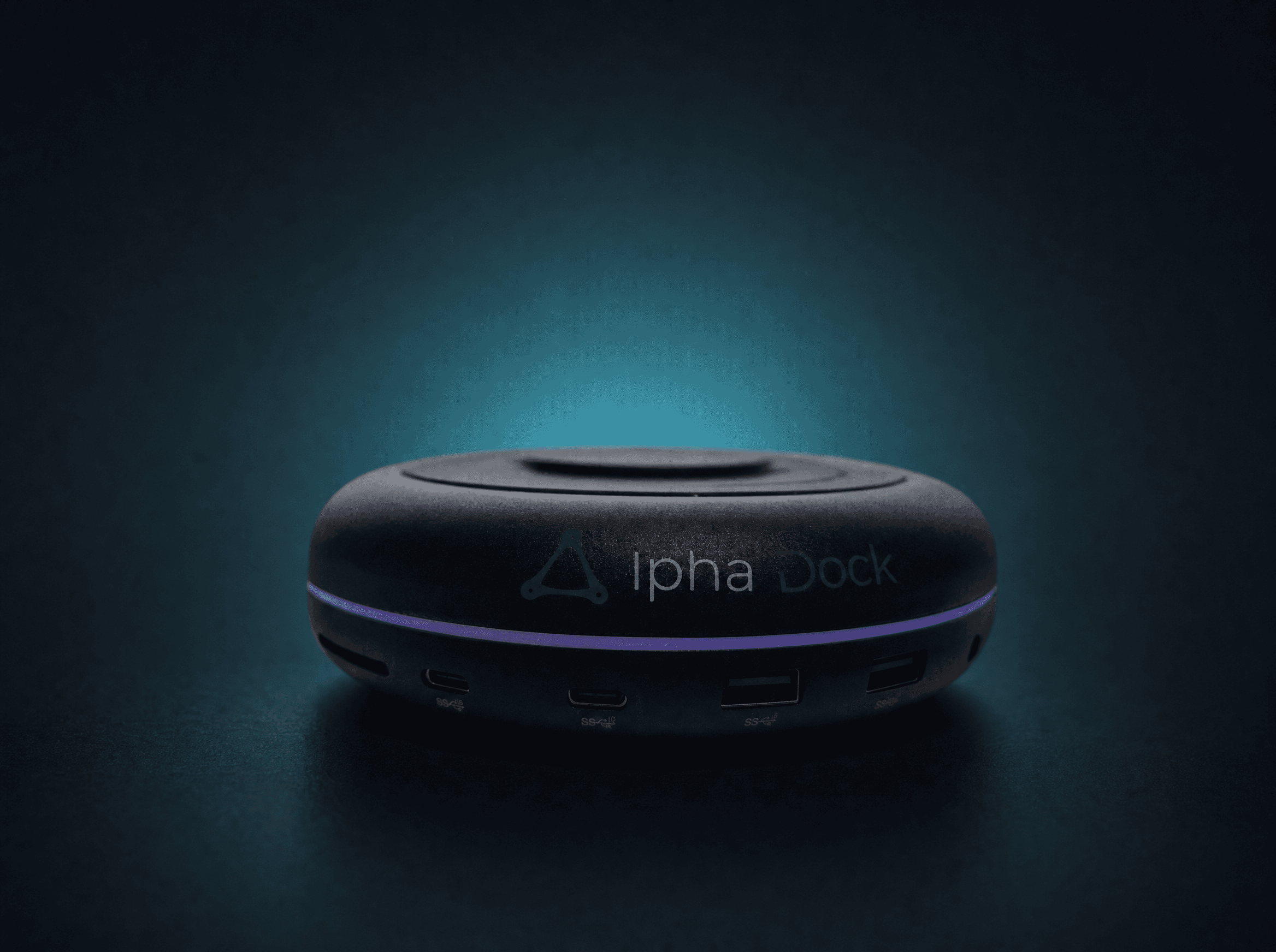 AlphaDock CL1 single unit — circular black aluminium Thunderbolt 5 docking station with Qi2 wireless charging pad on top
